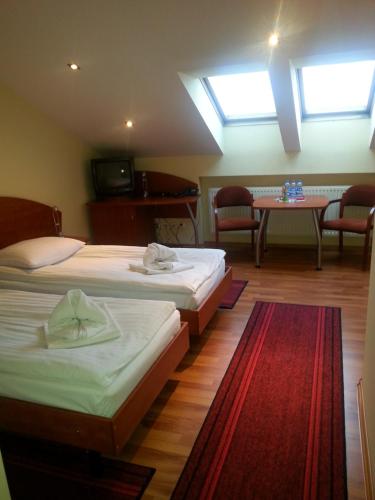 卡托维兹克加酒店及餐厅的一间客房配有两张床和一张桌椅