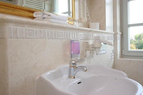 阿伦斯霍普基尔之家酒店的浴室设有白色水槽和镜子