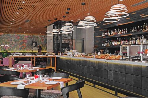 比勒陀利亚缅因门林首都酒店的一间带桌子的餐厅和一间提供葡萄酒的酒吧