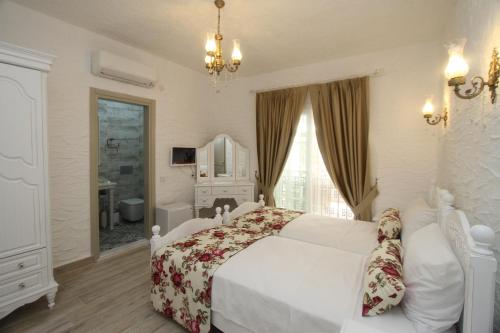 切什梅Alya Mou Butik Hotel的一间带白色床的卧室和一间浴室