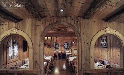 圣马蒂诺-迪卡斯特罗扎Hotel Stalon Alpine Chic的一间拥有木墙和两个拱门的用餐室