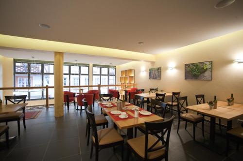 贝尔恩卡斯特尔-库斯Weingut & Gästehaus Schmitz-Bergweiler的餐厅内带桌椅的用餐室