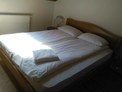 Luna de SusPensiunea Casa Szabi的一张带白色床单和枕头的床