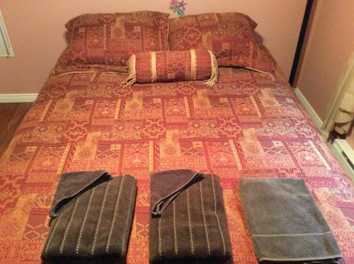 罗登露露和卢丹之家旅馆的一张带两个枕头的床和两张拖鞋