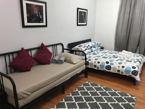 吉隆坡美托瓦尔服务公寓的客厅配有两张床和地毯。