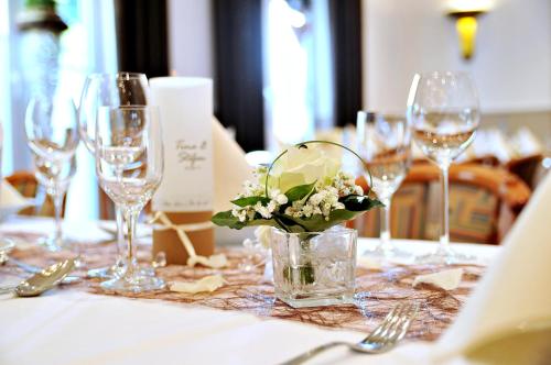 加瑞尔布格克劳斯塔普肯餐厅酒店的一张桌子,上面有酒杯和花瓶
