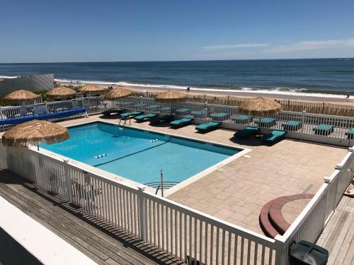 蒙托克海洋冲浪度假酒店的一个带遮阳伞和椅子的游泳池以及海滩