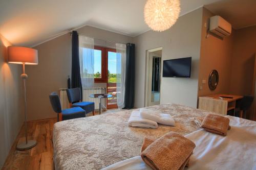 格拉博瓦茨Donna Plitvice Lakes的一间卧室配有一张大床和两条毛巾