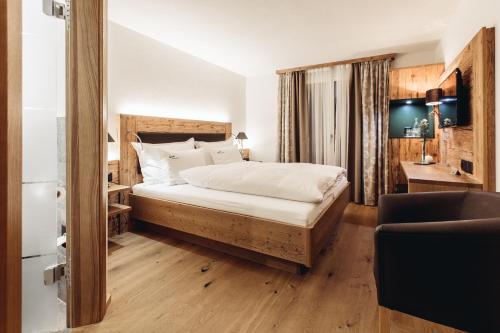 伦策海德斯贝克查酒店的一间卧室配有一张铺有木地板的白色床单。