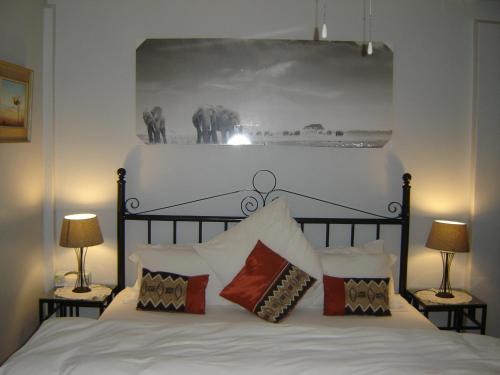 罗伯森雪松旅馆的卧室配有带两盏灯的白色床
