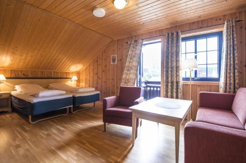 BerkåkBerkåk Gjestegård的一间卧室配有一张床、一张沙发和一张桌子