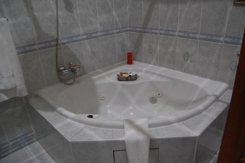 哈博罗内Falcon Crest Suites的瓷砖浴室设有白色浴缸。