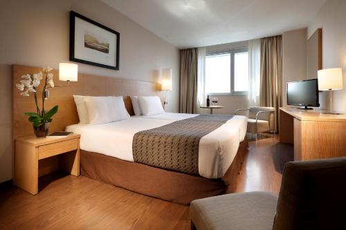 阿利坎特欧洲之星光明之城酒店的酒店客房,配有床和电视