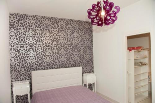 阿拉代奥Casa Fabiola的一间卧室配有紫色的床和紫色吊灯。