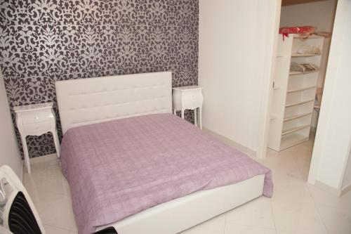 阿拉代奥Casa Fabiola的一间小卧室,配有一张带紫色毯子的床