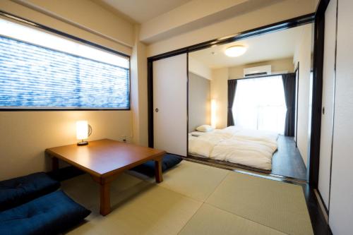 东京东京戈恩公寓式酒店的客房设有床、桌子和窗户。