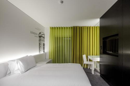 里斯本3K欧洲酒店的卧室配有白色的床和绿色窗帘