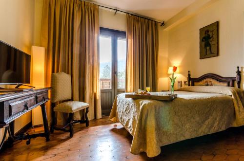 蓬费拉达Hotel Temple Ponferrada的酒店客房配有一张床、一张书桌和一台电视。