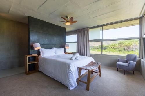 普利登堡湾Red Box Villa的一间卧室设有一张床和一个大窗户