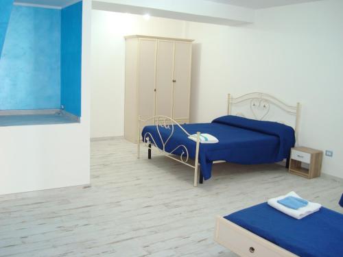 菲乌梅夫雷多布鲁齐奥Guest House Mare e Luna的一间卧室配有两张床和蓝色床单