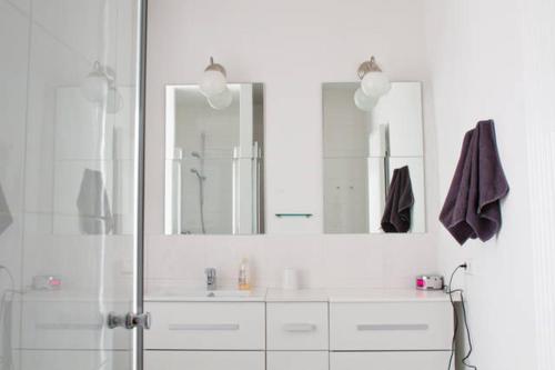 格拉茨Minihotel Graz的带淋浴和两面镜子的白色浴室