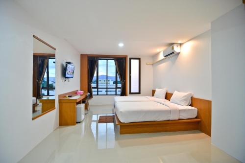 帕夭Sabuy Best Hotel Phayao的一间卧室配有一张床和一张书桌