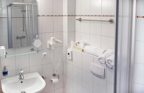 比苏姆Hotel Jess am Meer的白色的浴室设有水槽和淋浴。