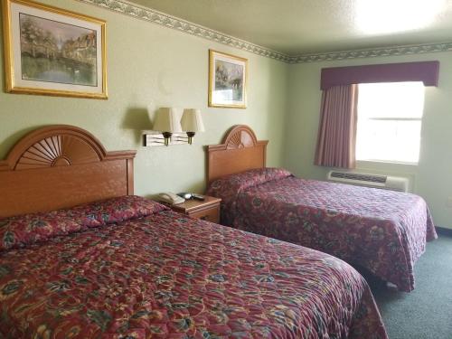 沃思堡沃斯堡霍尔特姆旅馆的酒店客房设有两张床和窗户。