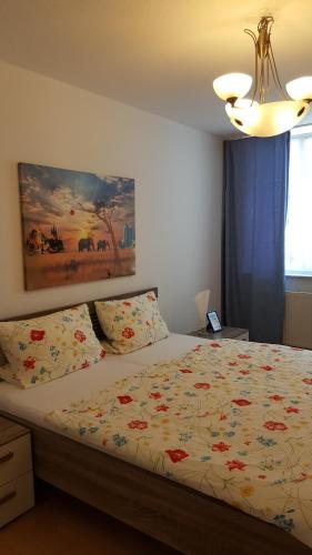 爱尔福特克雷默桥老城公寓的卧室配有一张床,墙上挂有绘画作品
