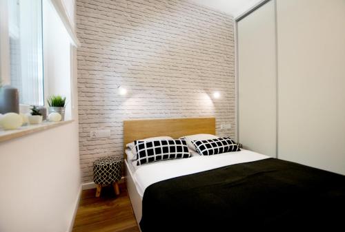 尤斯托尼莫斯基Apartament 27 Dwie Sosny的一间卧室设有一张床和砖墙