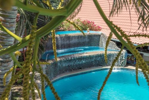 塔马林多最佳西方塔玛琳威斯塔别墅酒店的一个带保留墙和棕榈树的游泳池
