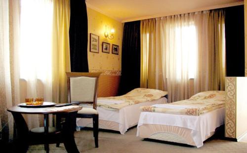 大特尔诺沃Guest Rooms Bela Neda的酒店客房设有两张床和一张桌子。