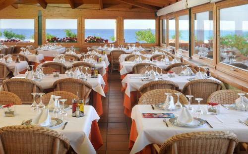 圣苏珊娜邦瑞珀斯阿露营酒店的餐厅设有白色的桌椅和窗户。