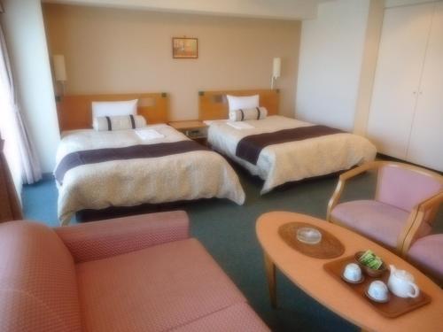 旭川旭川吴竹酒店的酒店客房,设有三张床和一张沙发