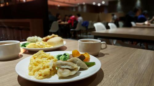 高雄河堤国际商旅的桌上的两盘食物和咖啡