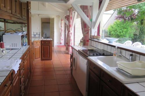 Seuilly圣阿布耶庄园旅馆的一个带木制橱柜和白色水槽的大厨房