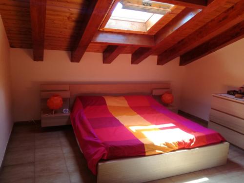 菲乌梅夫雷多迪西奇利亚Casa Jolie的一间卧室配有一张带五颜六色棉被的床