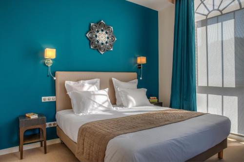 Méru特布莱特里酒店的蓝色卧室配有带白色枕头的床