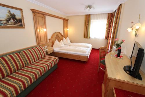 卡奇山口Gasthof Bacher的酒店客房设有一张沙发和一张床