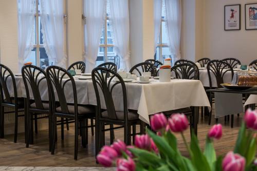 哈默尔恩加尼克里斯蒂伦贺夫历史酒店的用餐室配有桌椅和粉红色郁金香