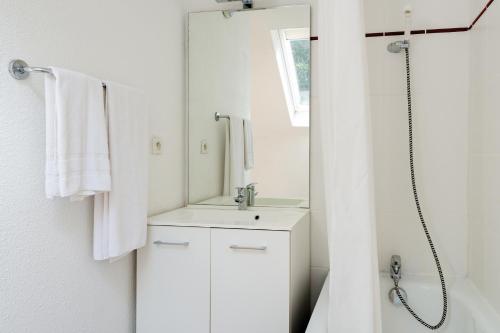 科特雷Lagrange Vacances Le Domaine des 100 Lacs的白色的浴室设有水槽和镜子