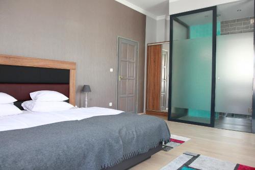 克塞洛Portré Apartman的一间卧室设有一张大床和玻璃墙
