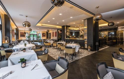 伦敦伦敦巴廖尼酒店-立鼎世酒店集团的一间设有白色桌椅的餐厅和一间酒吧