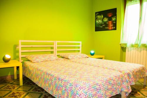 圣朱利亚诺-泰尔梅Sabry apartment的一间卧室设有一张床和绿色的墙壁