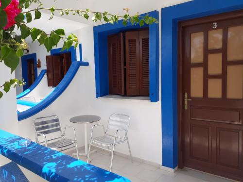 利普西岛Paradise Studios的拥有蓝色和白色墙壁、桌子和椅子的房子