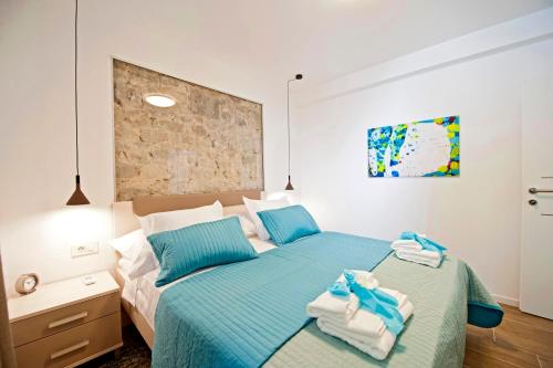 斯普利特Luxury Apartment Dvor的一间卧室配有蓝色的床和毛巾