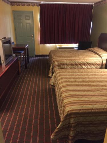 阿马里洛Camelot Inn的酒店客房设有两张床和一台平面电视。