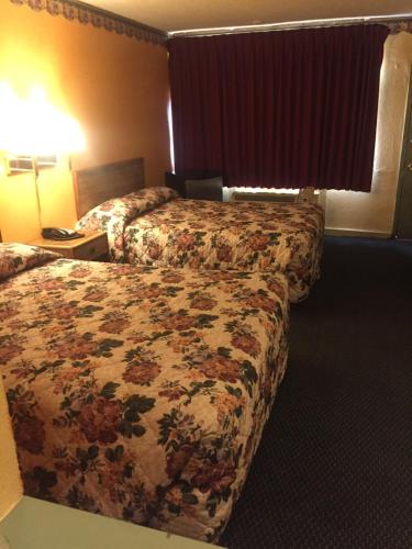阿马里洛Camelot Inn的酒店客房 - 带2张床和花卉床罩