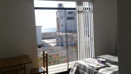 奇卡马港Chicama Surf Camp的一间卧室设有窗户,享有城市美景
