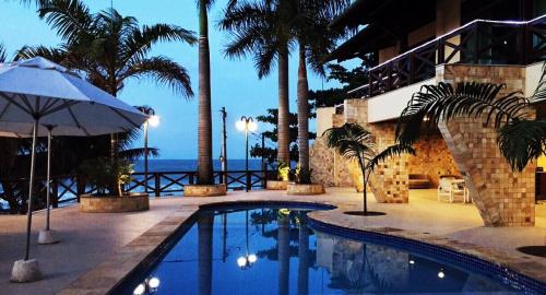 皮帕Pipa Mar Hotel的棕榈树和海洋度假村内的游泳池